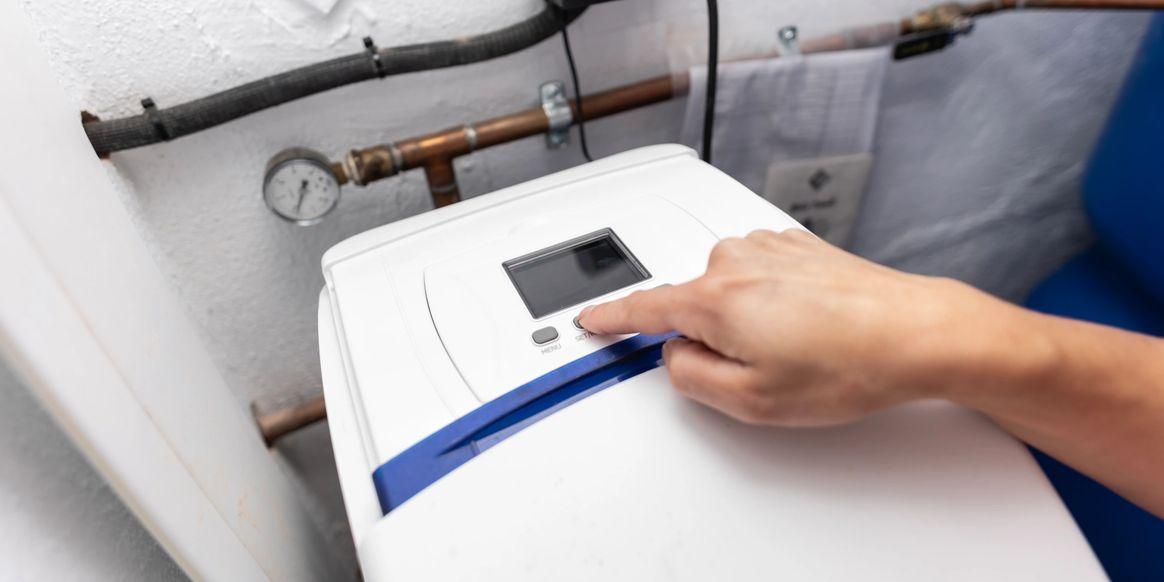 Technician adjusting a water softener control panel